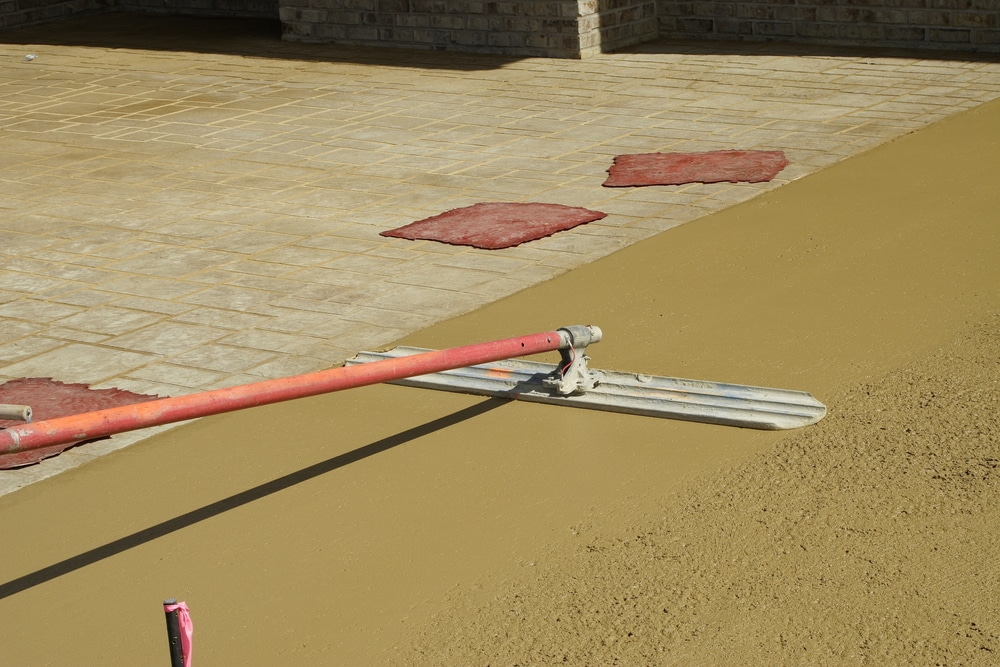 Concrete patio resurfacing Worker resurfacing newly constructed concrete patio for commercial usage